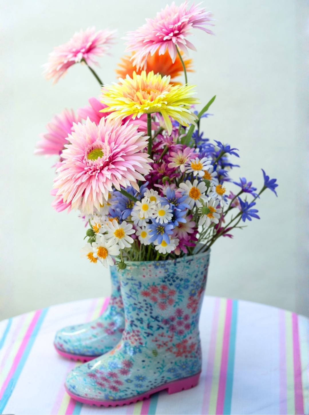 Silk flower arrangement in decorative boots